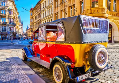 PRAGUE, CZECHIA - MARCH 11, 2022: Red retro car on the street of old town, on March 11 in Prague, Czechia