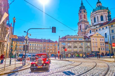 PRAGUE, CZECHIA - MARCH 11, 2022: Vintage car rides along Malostranske namesti square in the heart of Mala Strana district, on March 11 in Prague, Czechia