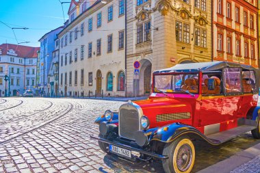 PRAGUE, CZECHIA - MARCH 11, 2022: Red retro Mercedes-Benz car cabriolet parked on the street in Mala Strana district, on March 11 in Prague, Czechia