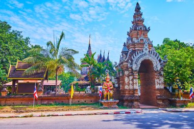 The brick gate of Wat Lok Moli, decorated with relief ornaments and Naga serpents sculptures, from the both sides of the gate one can see Yaksha guardians statues, Chiang Mai, Thailand