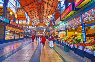BUDAPEST, HUNGARY - FEB 22, 2022: The numerous stalls of Central Market Hall offer fresh and tasty fruits and vegetables, on Feb 22 in Budapest