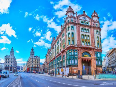 BUDAPEST, HUNGARY - FEB 22, 2022: Fast traffic on Lajos Kossuth Street, lined with historic buildings of Parisi Passage (Brudern House, Parisi Udvar) and Clotilde Palaces, on Feb 22 in Budapest