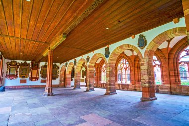 Large hall with stone arcades and view on Great Cloister, Basel Minster, Switzerland