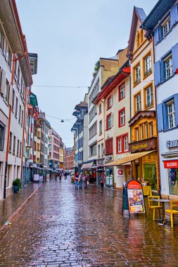 BASEL, SWITZERLAND - APRIL 1, 2022: Gerbergasse shopping street with numerous shops and boutiques on the ground floors of historical houses, on April 1 in Basel, Switzerland