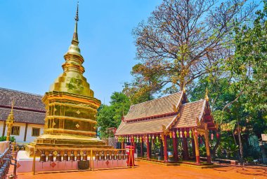 The small golden chedi of Wat Phra Singh, topped with hti umbrella and surrounded with ritual bells, Chiang Mai, Thailand