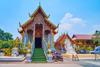 The medieval facade of the viharn of Wat Thung Yu, decorated with Naga serpent sculptures along the staircase, stone-teakwood columns, wooden gabel end and carved roof, Chiang Mai, Thailand