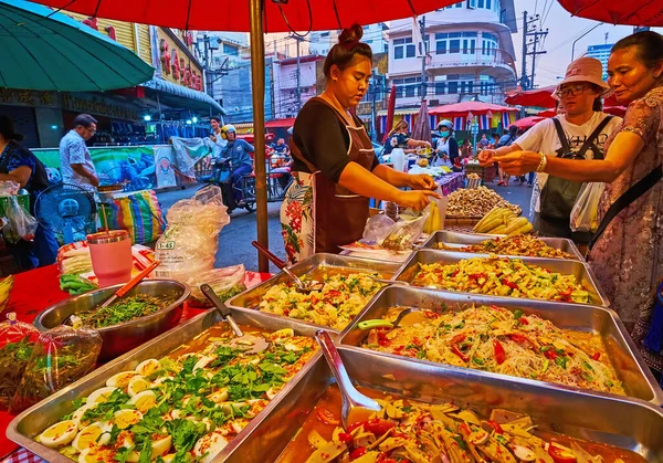 CHIANG MAI, THAILAND - MAY 3, 2019: The metal boxes with spicy stewed vegetable salads in a stall of Warorot Market, on May 3 in Chiang Mai