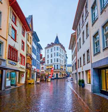 BASEL, SWITZERLAND - APRIL 1, 2022: The empty shopping Gerbergasse street during rainy day, on April 1 in Basel, Switzerland