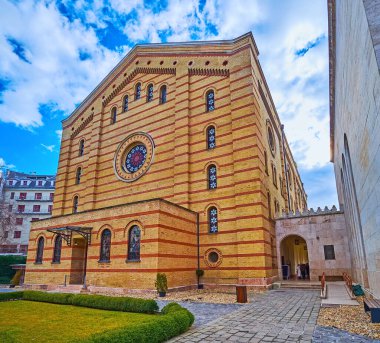 Historic building of Dohany Street Synagogue with brick wall, decorated with stripes of different color and stained-glass windows, Budapest, Hungary