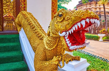 The beautiful gilt Mom aquatic creature statue guards the Ubosot of Wat Umong Mahathera Chan, Chiang Mai, Thailand