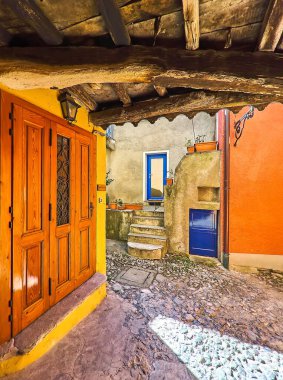 The maze of medieval streets of Castello with a view on the narrow passage with timber ceiling, Valsolda, Italy