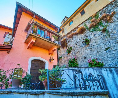 The beautiful house in old Gandria with plants in pots around it and the flowers along the alley, Ticino, Switzerland