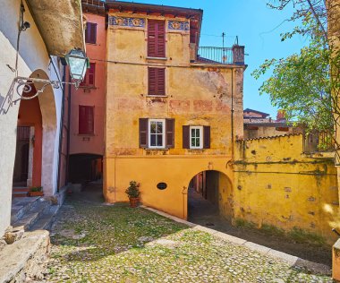Enjoy the old mountain town walk in Castello with narrow curved alleys and vintage colored houses, Valsolda, Lombardy, Italy