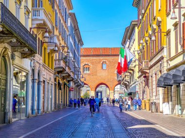 MONZA, ITALY - APRIL 11, 2022: Crowded Via Vittorio Emanuele II street with acrades of Palazzo dell'Arengario on background, on April 11 in Monza, Italy