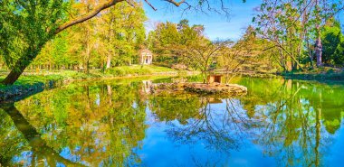 Küçük gölet (Laghetto di Villa Reale) yeşil adalı (Isoletta delle Anatre) ve ahşap evleriyle, Monza Royal Gardens, İtalya