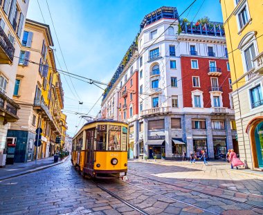 MILAN, ITALY - 11 Nisan 2022: 11 Nisan 'da İtalya' nın Milano kentinde Corso Magenta caddesi boyunca eski sarı tramvay yolculukları