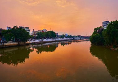 Ateşli günbatımı, Ping Nehri 'nin ayna benzeri yüzeyine yansıyor, Chiang Mai, Tayland