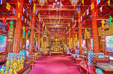 CHIANG MAI, THAILAND - 3 Mayıs 2019 Wat Saenfang Viharn 'inin güzel kırmızı gama namaz salonu sunakta yaldızlı Buda resimleri, yaldızlı sütunlar, Chiang Mai' de Mai 3 'te