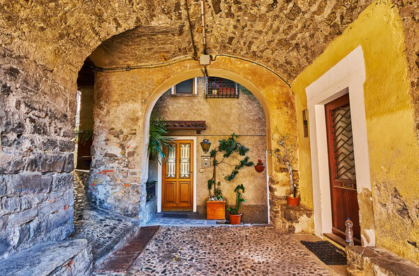 Walk down the medieval stone passage under the residential houses in old Albogasio, Valsolda, Italy