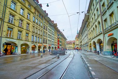 BERN, SWitzERLAND - 31 Mart 2022: Renkli Pfeiferbrunnen çeşmeli Spitalgasse caddesi ve atari salonlu tipik Bernese evleri, 31 Mart 'ta İsviçre' nin Bern kentinde