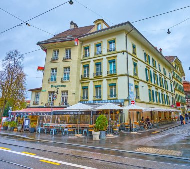 BERN, SWitzERLAND - 31 Mart 2022: Kornhausplatz meydanında restoranları ve kaldırım kafeleri olan iyi korunmuş ortaçağ binası, 31 Mart 'ta İsviçre' nin Bern kentinde