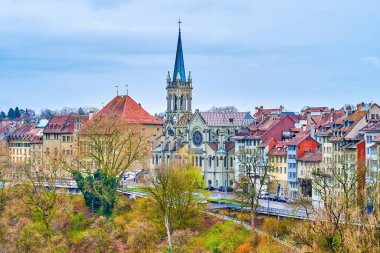 St. Peter ve Paul Kilisesi 'nin süslü çan kulesi, İsviçre' deki eski Bernese konak evlerini çevrelemektedir.