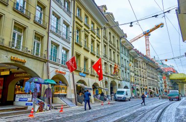 BERN, SWitzERLAND - 31 Mart 2022: Zemin katta yürüyen atari salonu ve mağazaları olan Bernese evleri, 31 Mart 'ta İsviçre' nin Bern kentinde