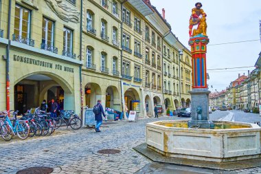 BERN, SWitzERLAND - 31 Mart 2022: Simsonbrunnen Çeşmesi Kramgasse caddesinde Samson heykeli ile birlikte 31 Mart 'ta İsviçre' nin Bern kentinde
