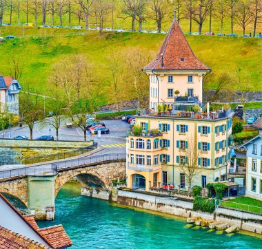 İsviçre 'nin Bern kentindeki Ortaçağ Untertorbrucke köprüsündeki Aare Nehri kıyısındaki tarihi binalar