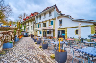 BERN, SWitzERLAND - 31 Mart 2022: Yağmurlu bir günde, 31 Mart 'ta İsviçre' nin Bern kentinde restoranın açık hava yemeği