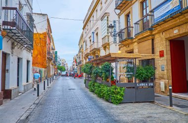 EL PUERTO, SPAIN - 21 Eylül 2019: 21 Eylül 'de İspanya' nın El Puerto kentinde eski şehir caddesinde klasik evler, oteller, açık hava yemekleri ve dükkanlarla dolu bir yürüyüş