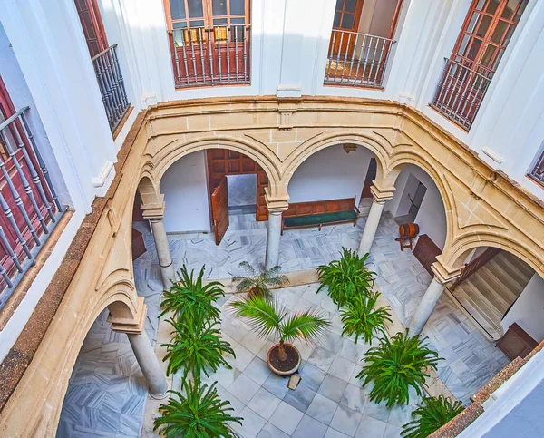 The top view of the small courtyard of historic Aranibar Palace, decorated with green plants in pots, El Puerto, Spain