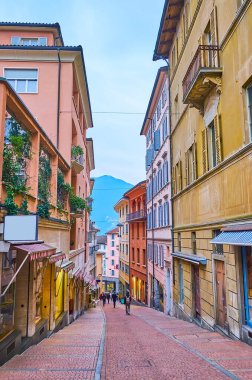 Via Cattedrale 'in nazik inişi, dükkanları ve restoranları olan retro evlerle dolu, Lugano, İsviçre