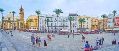 İspanya 'nın Cadiz kentindeki Plaza de la Katedral' deki tarihi kasaba evleri, açık hava restoranları ve Santiago Apostol Kilisesi Panoraması
