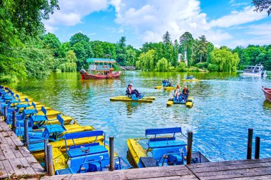 UMAN, UKRAINE - 16 Haziran 2021: Çocuklar Uman, Ukrayna 'daki Sofiyivka Parkı' ndaki Yukarı Göl 'de katamaranlarla yelken açtılar