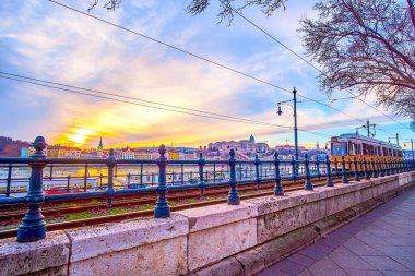 Budapeşte 'nin akşam gökyüzü manzaralı ve Macaristan' ın Tuna nehri boyunca sarı tramvaya binen