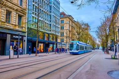 ZURİH, SWitzERLAND - 3 Nisan 2022: Bahnhofstrasse, İsviçre 'nin Zürih kentinde 3 Nisan' da şehir merkezindeki ana cadde ve lüks butiklerin evidir.