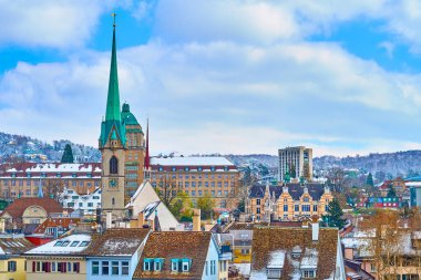 Predigerkirche kilisesinin yüksek kulesi İsviçre 'nin Zürih kentindeki ortaçağ evlerinin çatılarından yükseliyor.