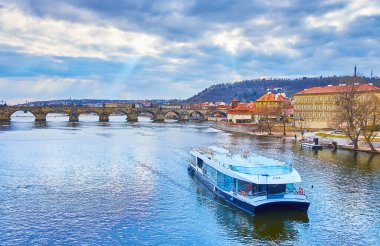 Charles Bridge, Lesser Quarter ve Petrin Hill arka planda, Prag, Çek Cumhuriyeti 'nde bir turizm gemisi.