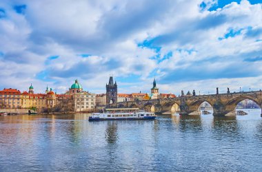 Vltava Nehri 'ndeki turist teknesi Charles Köprüsü' ne ve Prag, Çek Cumhuriyeti 'ndeki Old Town' a karşı.