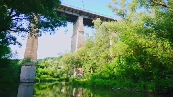 乌克兰Kamianets Podilskyi 一座横跨Smotrych河峡谷的高耸的混凝土新桥穿过茂密的森林绿地 — 图库视频影像