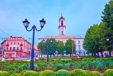 Merkezi Meydan 'da çiçek açan çiçeklerle dolu manzaralı çiçek tarhı tarihi belediye binasının önünde, Chernivtsi, Ukrayna