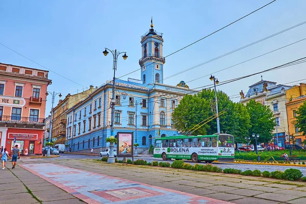 CHERNIVTSI, UKRAINE - 16 Temmuz 2021: Tarihi yapılar ve belediye binası ile Merkez Meydanı 'ndaki akşam trafiği, 16 Temmuz' da Chernivtsi 'de yüksek kuleyle kaplandı.