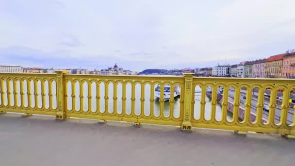 ドナウ川を望むマーガレット ブリッジのヴィンテージ メタル レール 装飾された船とゴシック様式の議会の建物 ブダペスト ハンガリー — ストック動画