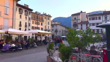 COMO, ITALY - 20 Mart 2022: Alessandro Volta Meydanı açık hava restoranları ile süslenmiş yeşil santraller ve tarihi binalar, 20 Mart 'ta Como