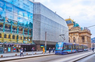 PRAG, CZECH REPUBLIC - 7 Mart 2022: Ulusal Tiyatro binalarının Narodni Bulvarı 'ndaki istasyondaki modern tramvaylar, 7 Mart' ta Prag 'da