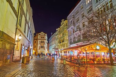 PRAG, CZECHIA - 7 Mart 2022: Küçük restoranları, barları, tarihi evleri ve Altın Kuyu 'daki (Dum u Zlate Studne) duvar heykelleri olan Karlova Caddesi