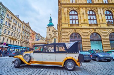 PRAG, CZECHIA - 7 Mart 2022 Havelska Caddesi 'ndeki klasik araba 7 Mart' ta Prag 'da St. Havel Kilisesi çan kulesine karşı.
