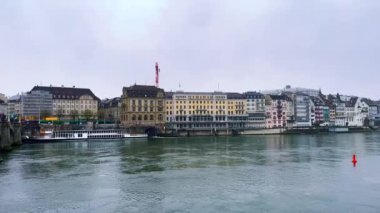 Ren Nehri, Orta Köprü (Mittlere Brucke) ve İsviçre 'nin karşı kıyısındaki Grossbasler Altstadt' ın tarihi mimarisi ile yağmurlu Basel Panoraması