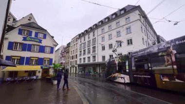 Tramvaylar, Barfusserplatz Meydanı 'nın İsviçre' nin Basel, Basel kentindeki modern ve antika evleri arasında yol almaktadır.